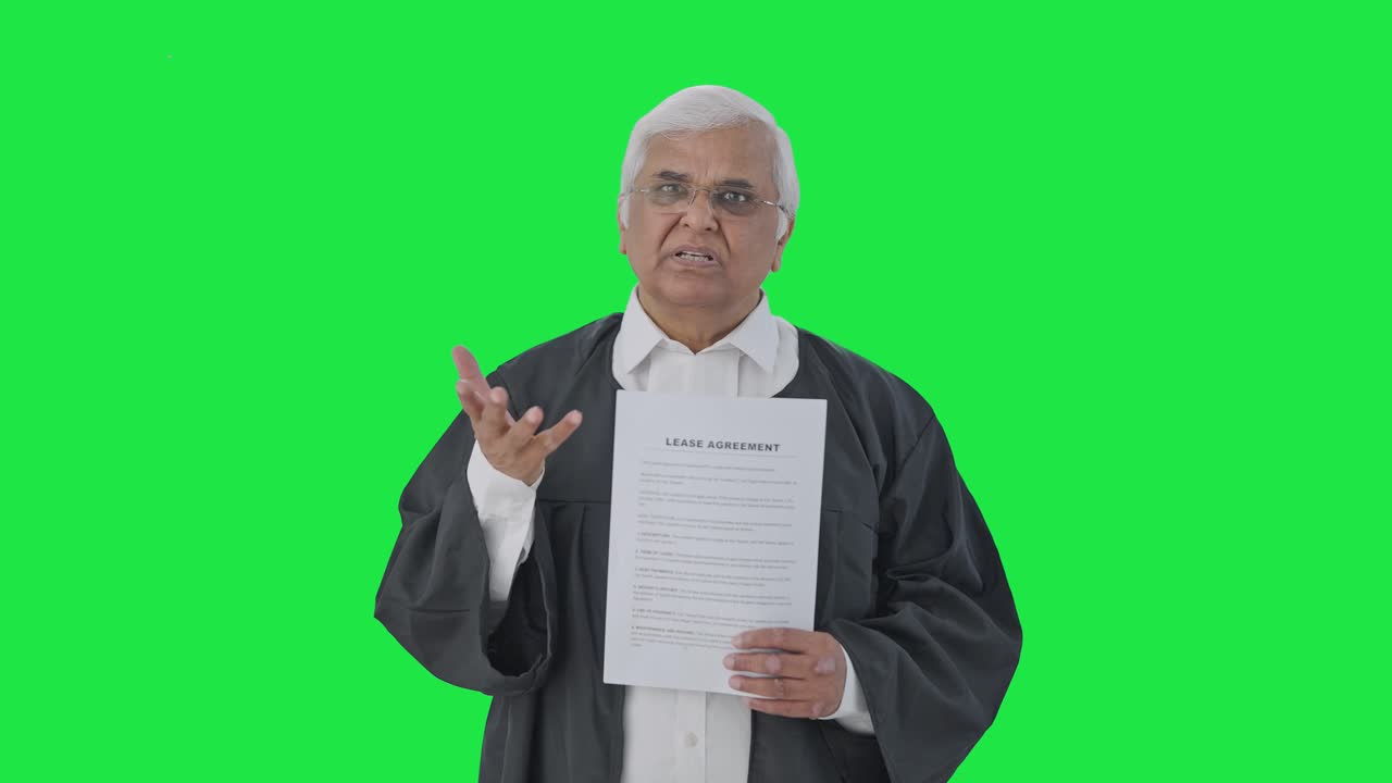 Avvocato indiano anziano che presenta il suo caso in tribunale davanti a uno schermo verde