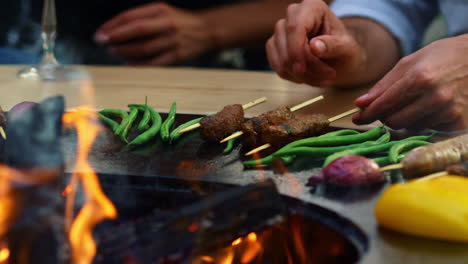 Unrecognizable-guy-cooking-meat-on-sticks-on-grill