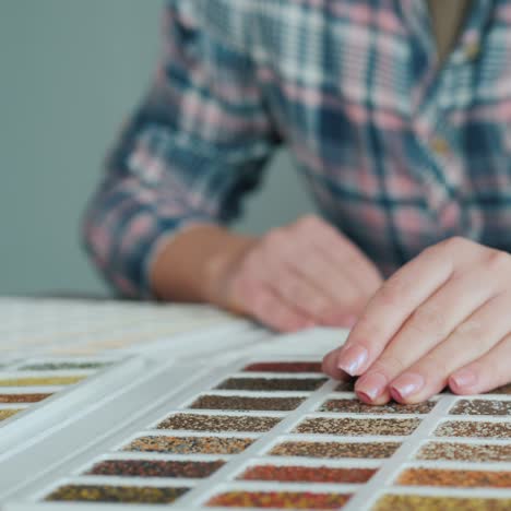 la mano de una mujer en un palé con muestras de decoración