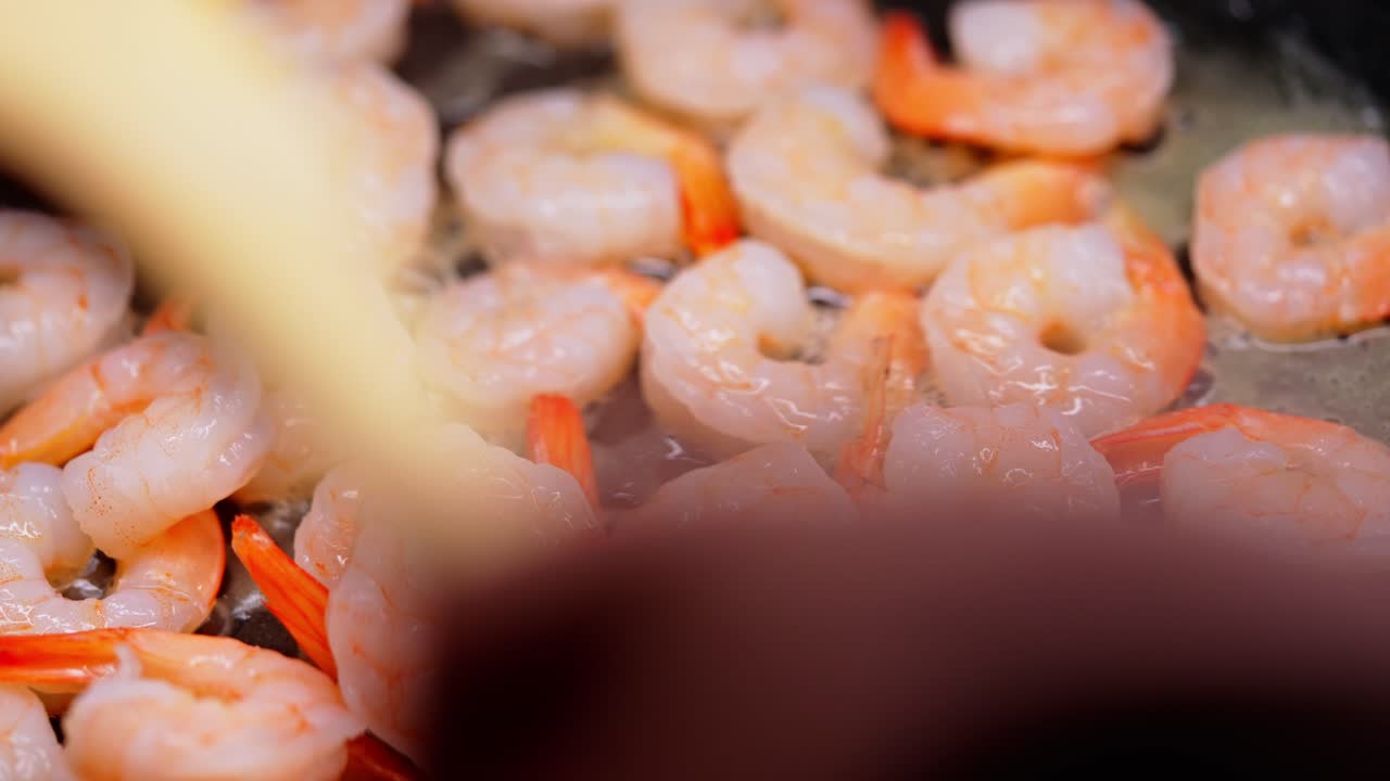 Juicy shrimps sizzle in butter, cooking in a hot pan with a golden glow