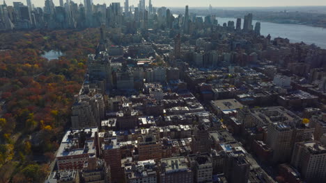 Aerial-view-of-multistorey-buildings-in-town.-Colourful-autumn-trees-in-Central-Park.-Modern-high-rise-towers-in-background.-Manhattan,-New-York-City,-USA