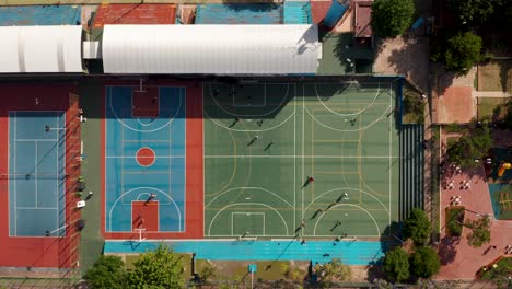 top view of basketball court and soccer fields with players playing under the sun