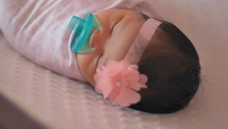 primer plano de un bebé recién nacido envuelto en una manta acostado en una cuna