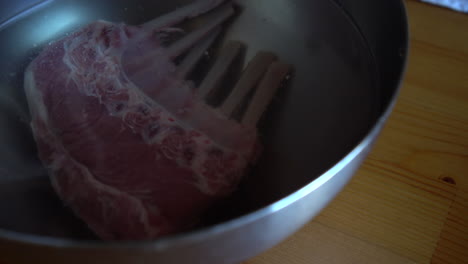 chef washing a rack of lamb, food preparation