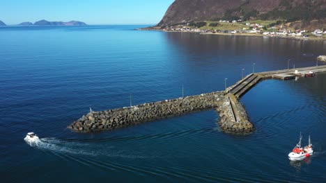 Fishing-boats-sail-out-of-the-harbor-on-Godøya,-a-small-island-outside-Ålesund-in-Norway