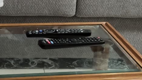 2 remote controls on a table in a living room, in a suburban home in Cape Town.