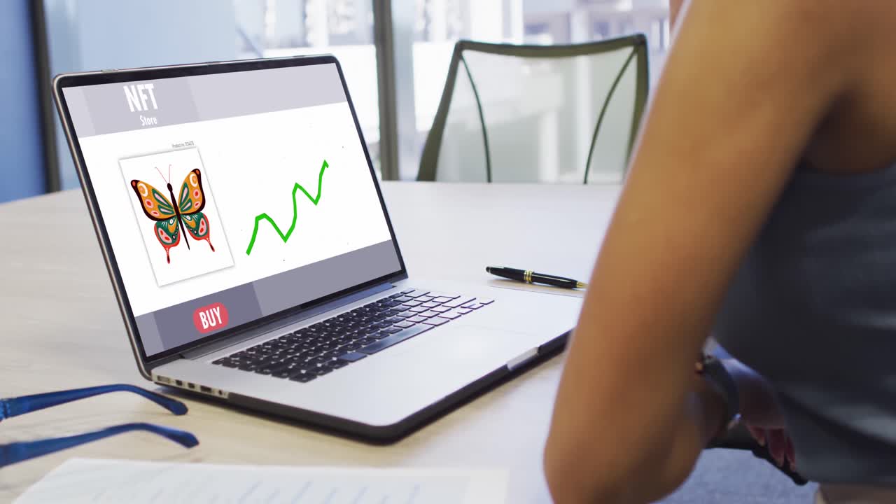 video de una mujer biracial trabajando en una computadora portátil con nft en la pantalla