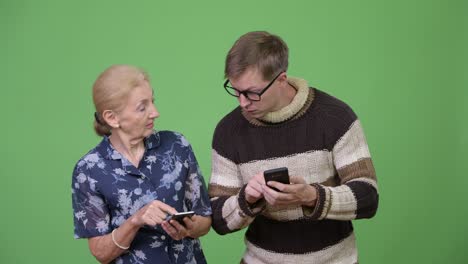 happy grandmother and grandson using phone and talking together