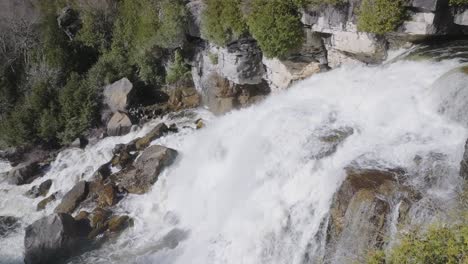 Cascada-Precipitada-Sobre-Acantilados-Rocosos-Rodeados-De-Un-Exuberante-Bosque-Verde-En-Owen-Sound,-Canadá