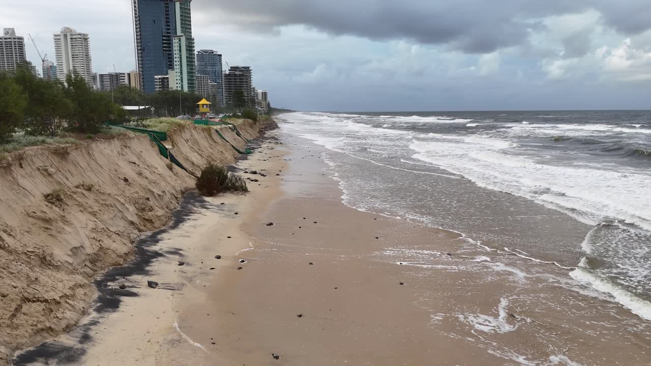 A 16-second video captures severe coastal erosion on a Gold Coast beach, highlighting environmental impact under overcast skies