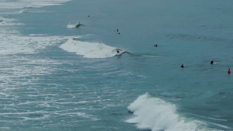 surfer getting up and riding a wave in ocean, south america, brazil, summertime