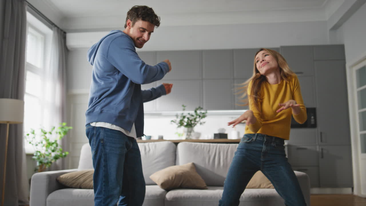Carefree lovers dancing together at home. Happy romantic husband wife having fun