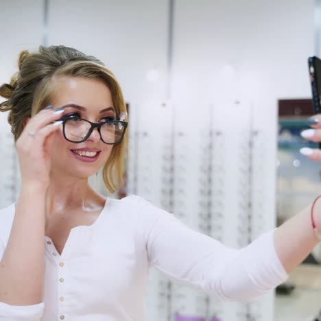 woman choosing glasses with phone