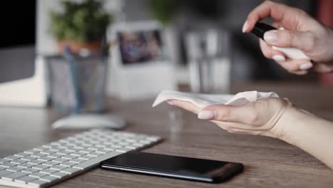 handheld video of woman cleaning phone in the office