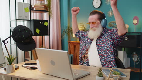 happy man dancing at his desk while listening to music