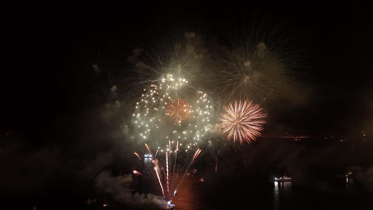 vista panorámica de fuegos artificiales rojos que generan destellos de luz sobre un humo, ciudad de valparaíso, chile