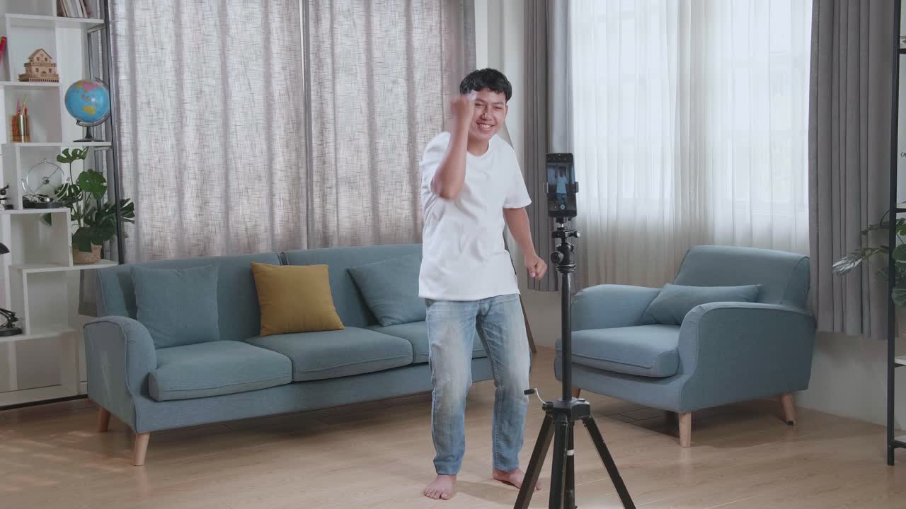 Asian Boy Dancing While Shooting Video Content For Social Networks With A Smartphone Camera
