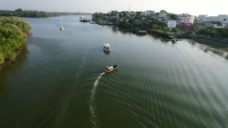 Aerial-drone-of-a-Thai-longtail-boat-on-the-river-arriving-in-Krabi-Town-Thailand-during-summer-at-sunset