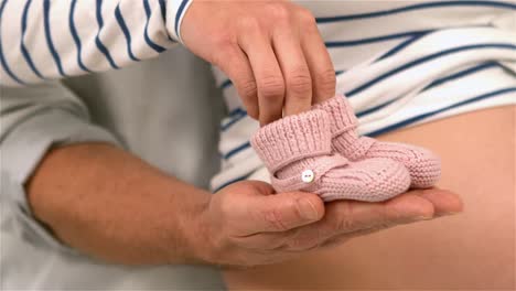 Couple-holding-baby-shoes