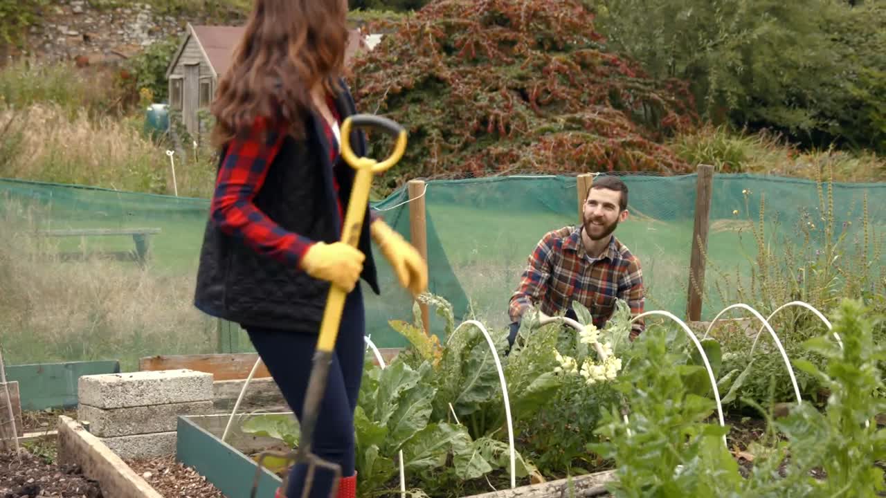 una pareja joven haciendo jardinería.