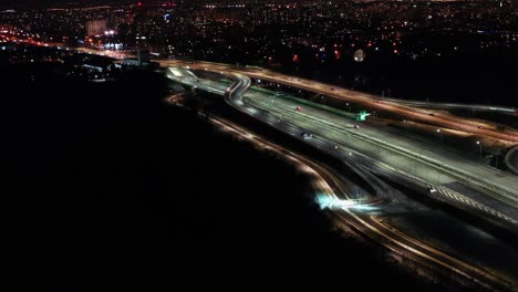 Sobrevuelo-Aéreo-Carretera-De-Intercambio-De-Atascos-De-Tráfico-Por-La-Noche,-Tiro-De-Drones-Vista-De-Arriba-Hacia-Abajo-Intersección-De-La-Carretera-En-La-Ciudad-Moderna-Por-La-Noche