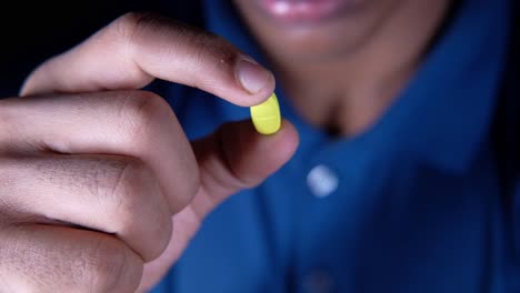 person holding a yellow pill