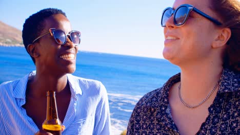 Female-friends-having-beer-in-the-beach-4k