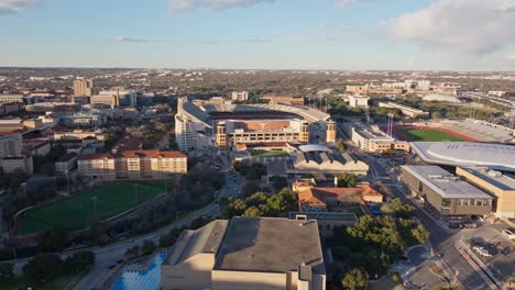 a wide drone shot at sunset panning left revealing and the empty darrell k royal texas memorial stadium at the university of texas (ut) in austin and the surrounding videos