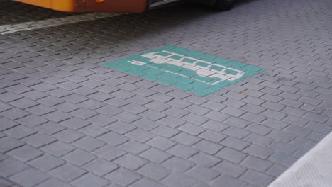 electric bus leaving the energy station after recharging the battery, passing the charging logo sign on the ground