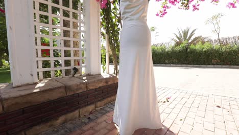 white dress mankin in outdoor wedding surrounded by decoration full of flowers and trees low angle shot