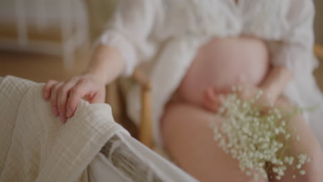 pregnant woman cradling baby to sleep with flowers