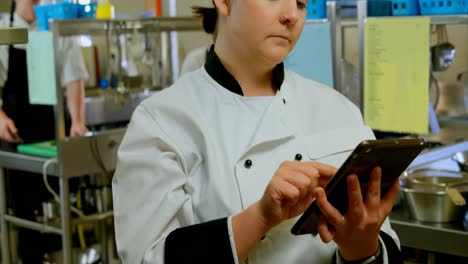 female chef using digital tablet in kitchen 4k