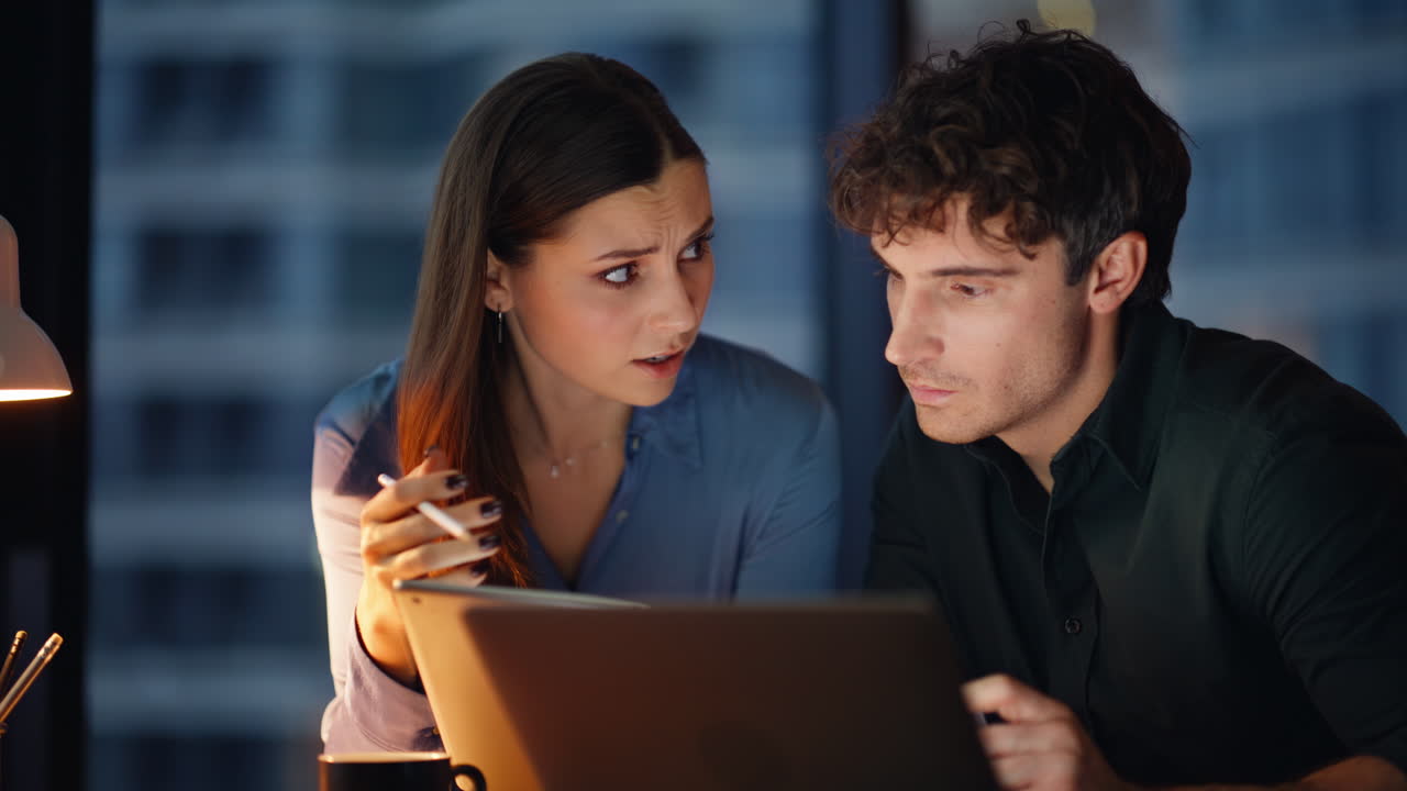 Two managers analyzing project looking tablet data at dark office closeup