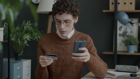 young man checking online payment with credit card