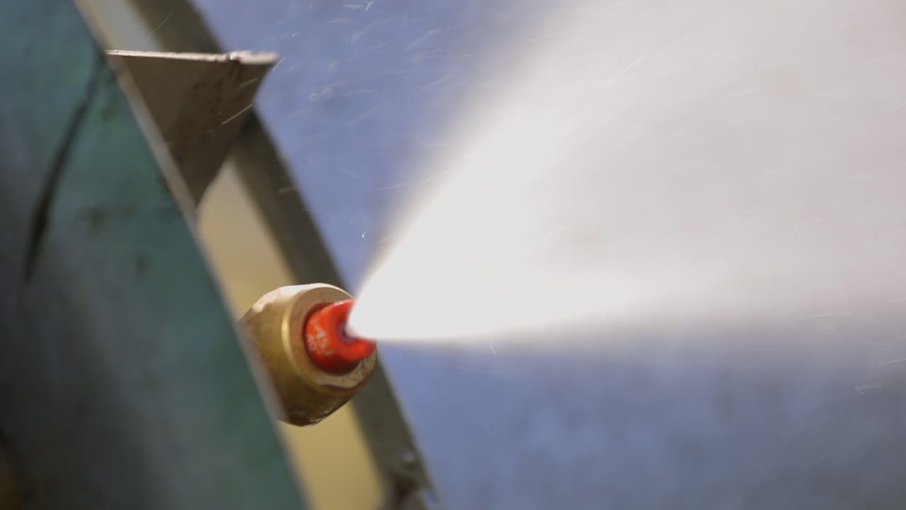 Vista dettagliata in primo piano di un ugello irroratore che spruzza pesticida liquido.