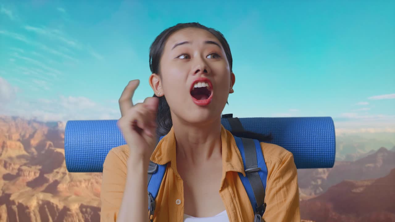 Close Up Of Asian Female Hiker With Mountaineering Backpack Thinking About Something And Looking Around Then Raising Her Index Finger While Traveling At The Top Of Mountain