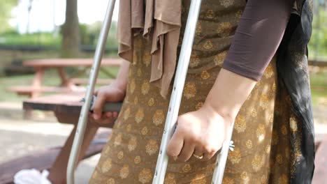 woman using crutches in a park