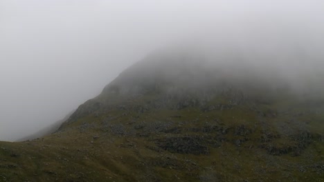 A-shot-of-the-mist-and-fog-rolling-over-a-mountain-near-the-village-of-Tarbert-on-the-Isle-of-Harris,-part-of-the-Outer-Hebrides-of-Scotland