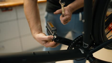 Mechanic disassembles a bicycle to repair the pedals and bottom bracket