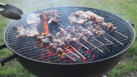 Dar-La-Vuelta-A-Las-Costillas-De-Cerdo-Mientras-Se-Asan-A-La-Parrilla-En-Una-Barbacoa-De-Carbón