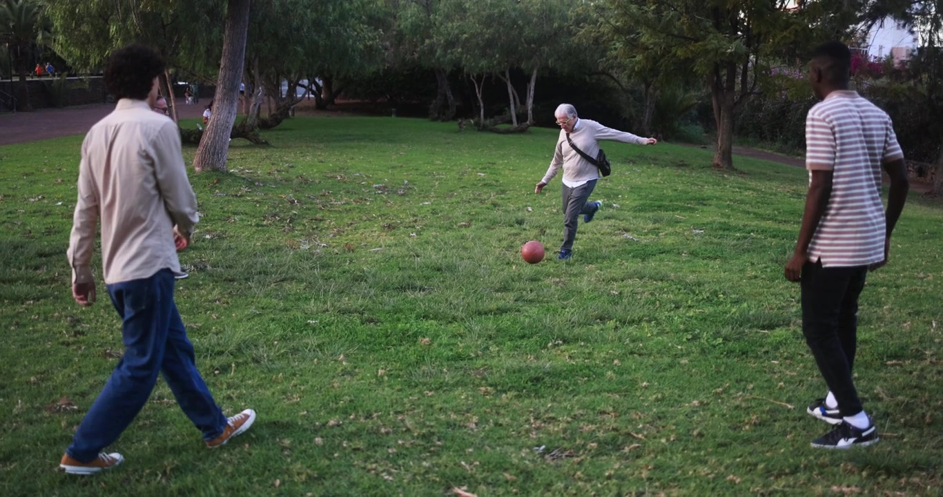 Diverse Group of Men Playing with a Ball in a Green Park