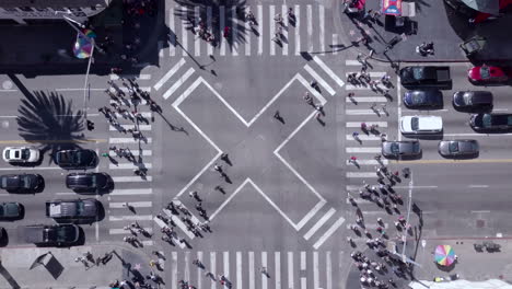 Busy crosswalk intersection. Crowds of both tourists and other city people cross diagonally through a bustling part of town. Shot in Hollywood, Los Angeles