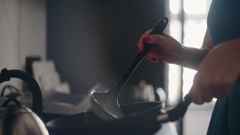 frying-pancakes-for-breakfast-closeup-view-of-woman-hands-with-frying-pan-and-ladle-with-dough