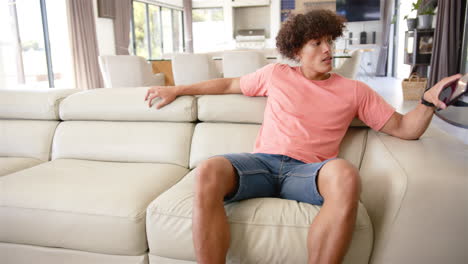 relaxing on sofa, man in casual clothes looking surprised in modern living room, copy space
