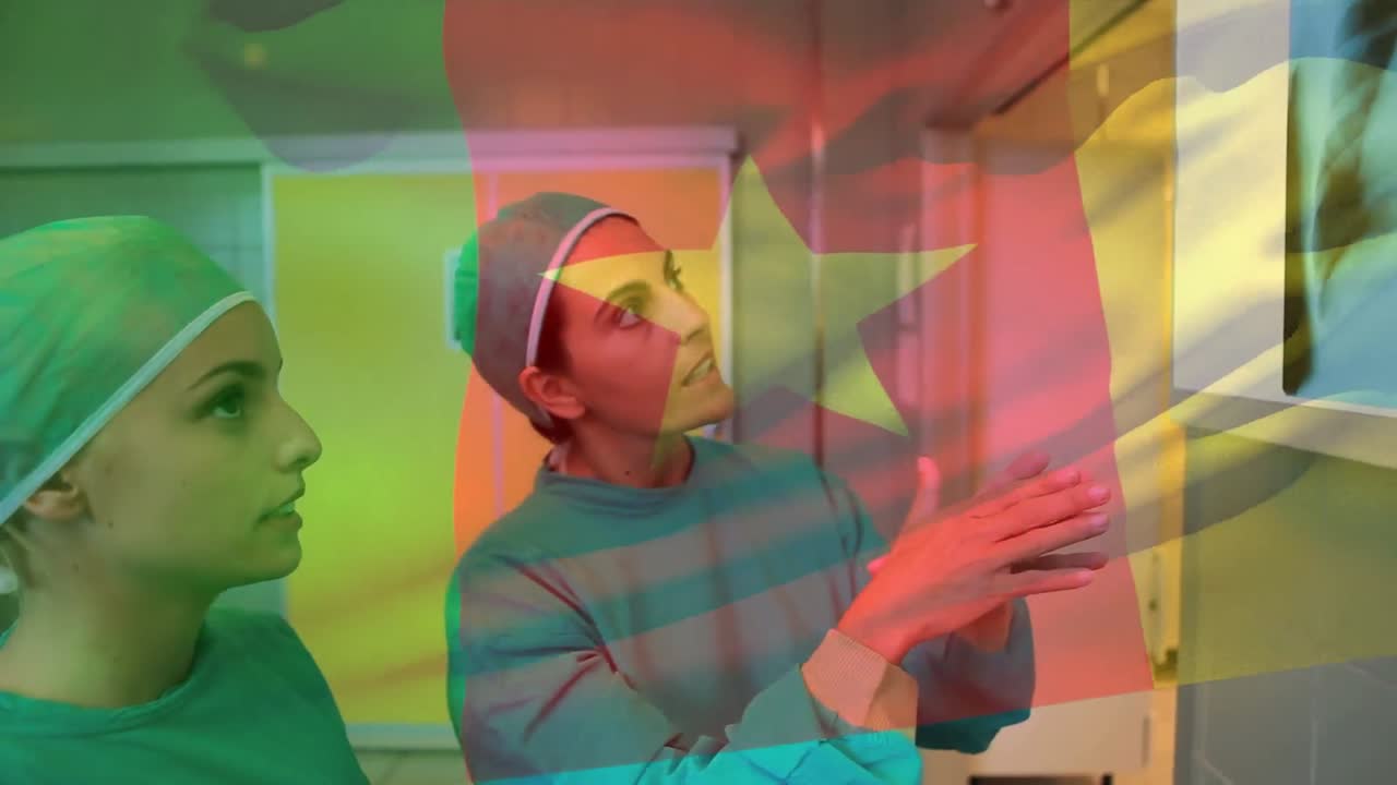 Animation of flag of cameroon over caucasian female doctors talking