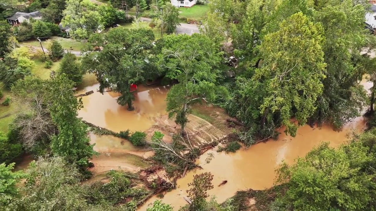 Riprese aeree con drone a Greenville, Carolina del Sud, dell'alluvione causata dall'uragano Helene, con l'acqua che copre i giardini delle case da un ruscello vicino