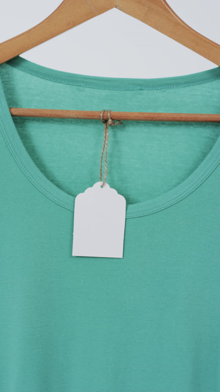 Vertical video of green t shirt on hanger and copy space on white background