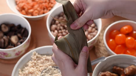 Making zongzi food - preparing and wrapping Chinese rice dumpling.