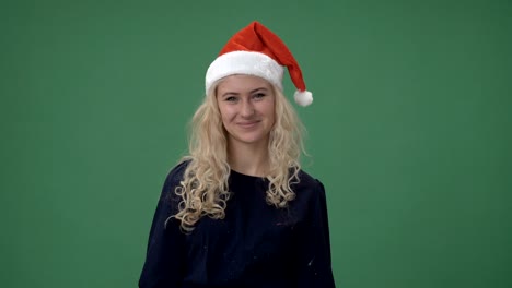 joven rubia con una gorra roja de navidad sonriendo, pantalla verde clave de croma