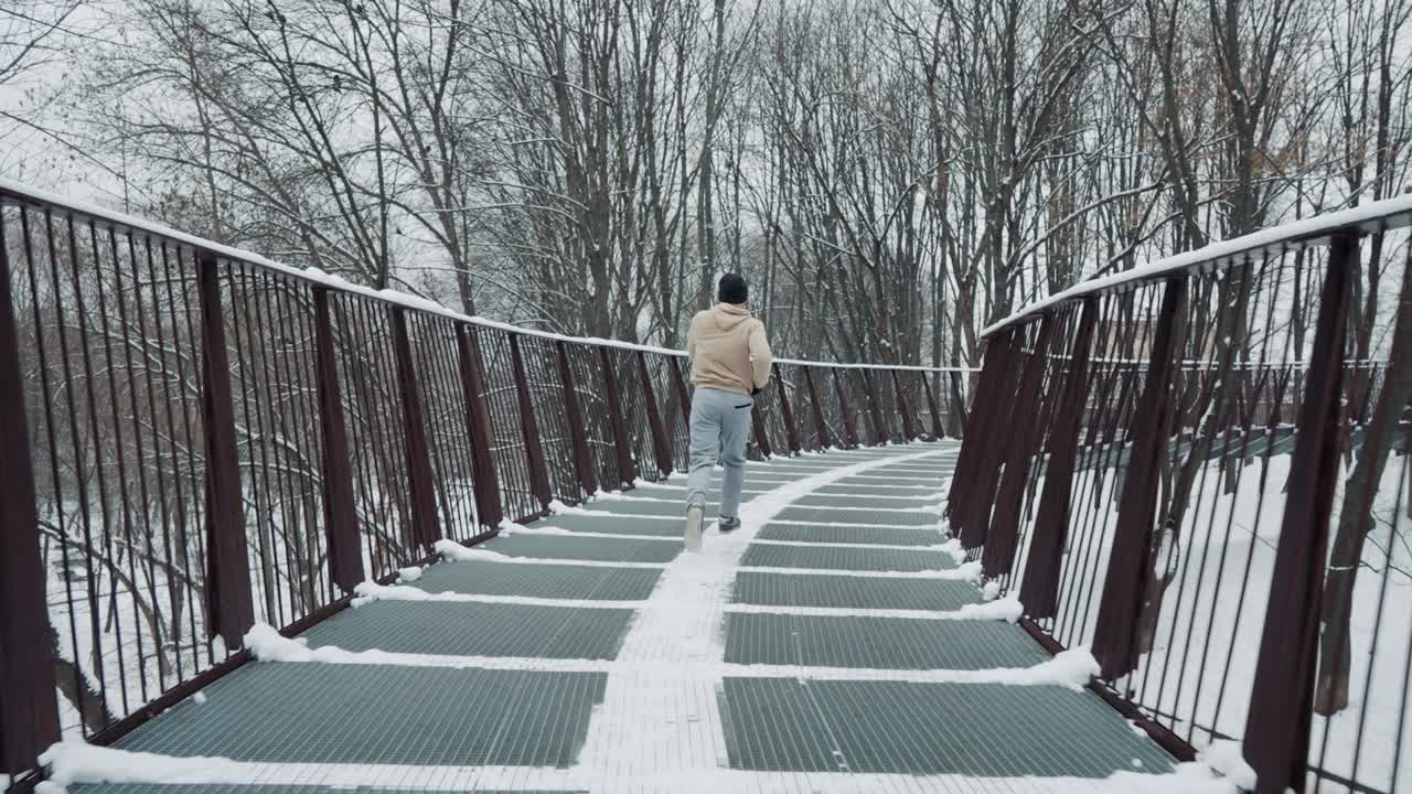 겨울에 다리에서 조하는 느린 동작의 남자